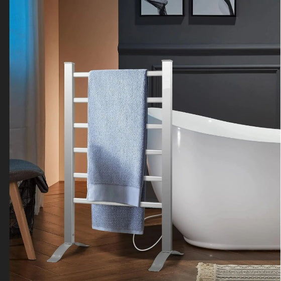 White towel rack with a blue towel hanging on it next to a white bathtub in a bathroom.