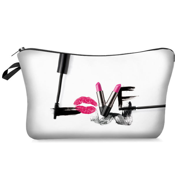 Clear makeup bag with black brush strokes, pink lipstick, and red lip print on a white background