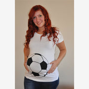 Woman wearing a white t-shirt with a soccer ball design, standing against a plain background.