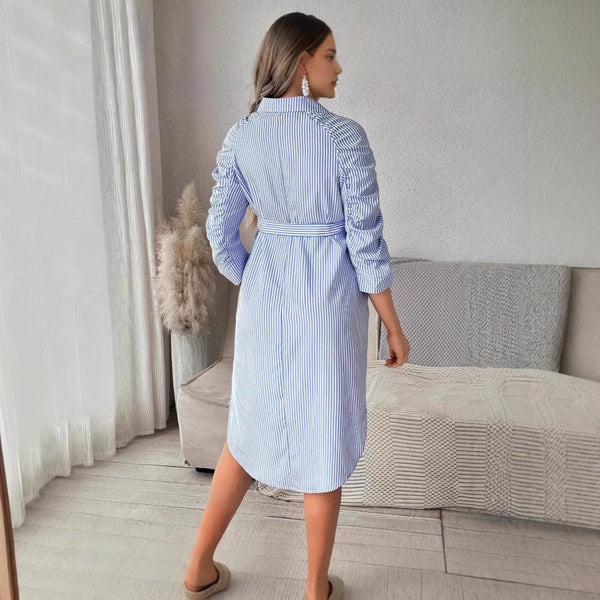 Woman wearing a blue and white striped dress in a living room setting