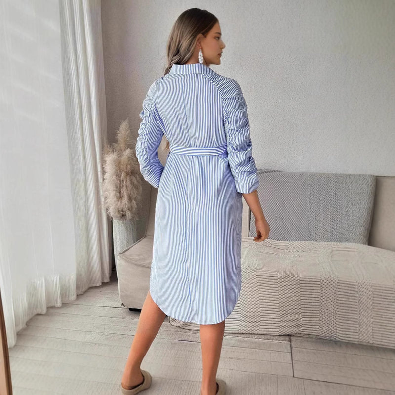 Woman wearing a blue and white striped dress in a living room setting