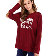 Woman wearing a red 'Mama Bear' sweatshirt on a white background
