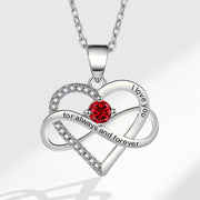 Heart-shaped silver necklace with a red gemstone and engraved text on a white background