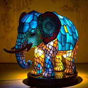 Colorful elephant-shaped lamp with stained glass design on a wooden surface.