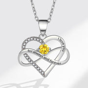 Silver heart-shaped pendant with a yellow gemstone and engraved text on a white background