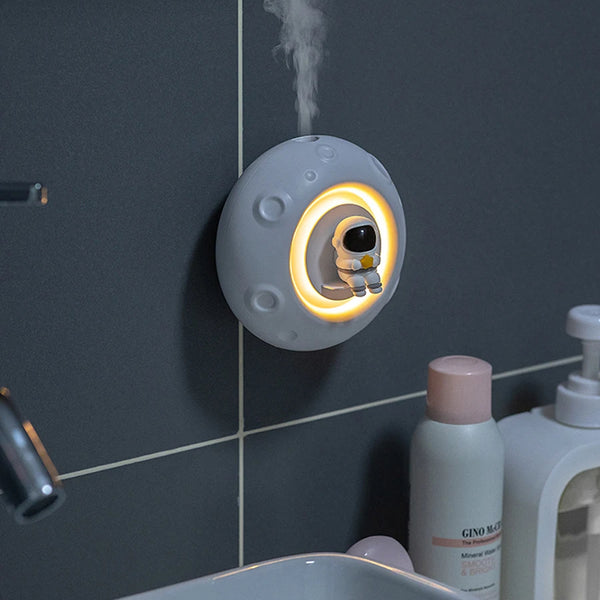 Small round device emitting steam on a bathroom wall with toiletries below.