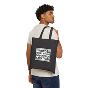 Man carrying a black tote bag with text on a white background