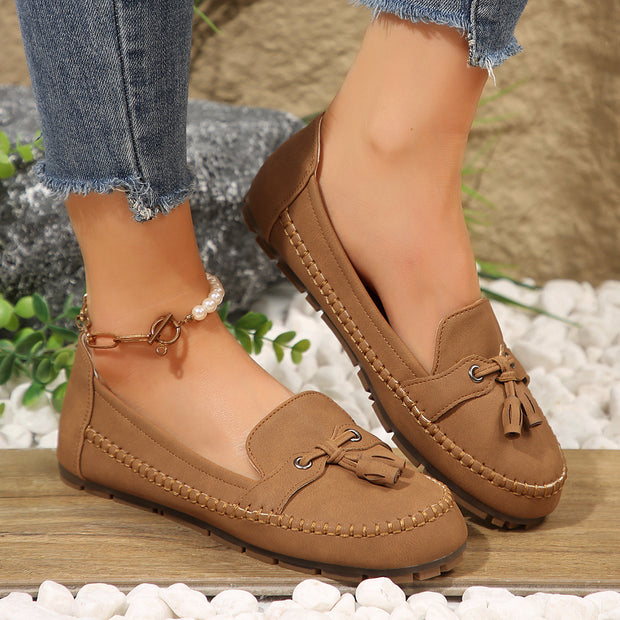 Brown loafers worn with jeans on a natural background
