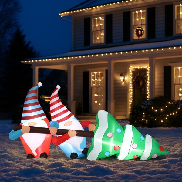 Inflatable Christmas gnomes and tree in front of a house with holiday lights.