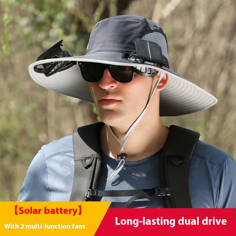 Person wearing a wide-brimmed hat with solar battery and fans, outdoors.