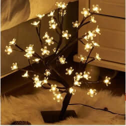Decorative LED tree with lights on a wooden floor.
