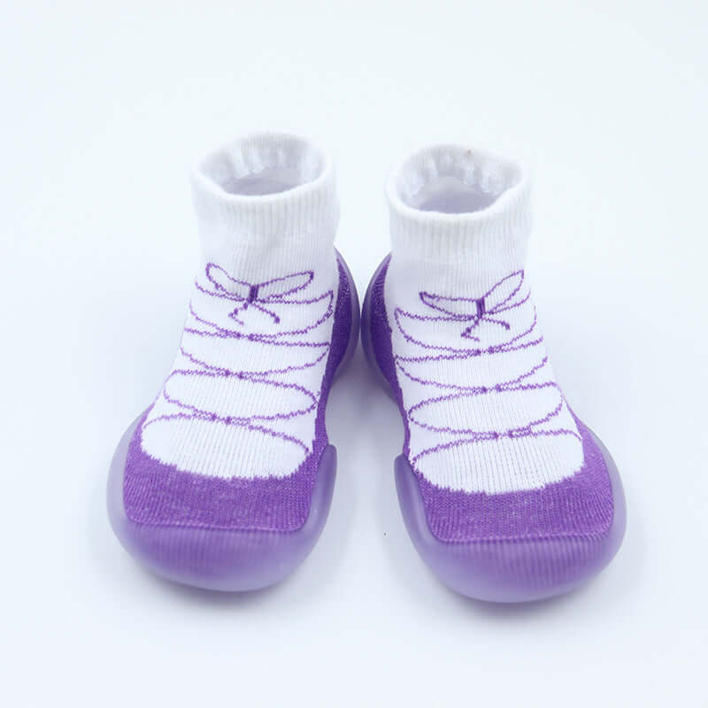 Pair of white socks with purple sole and dragonfly design on a light gray background