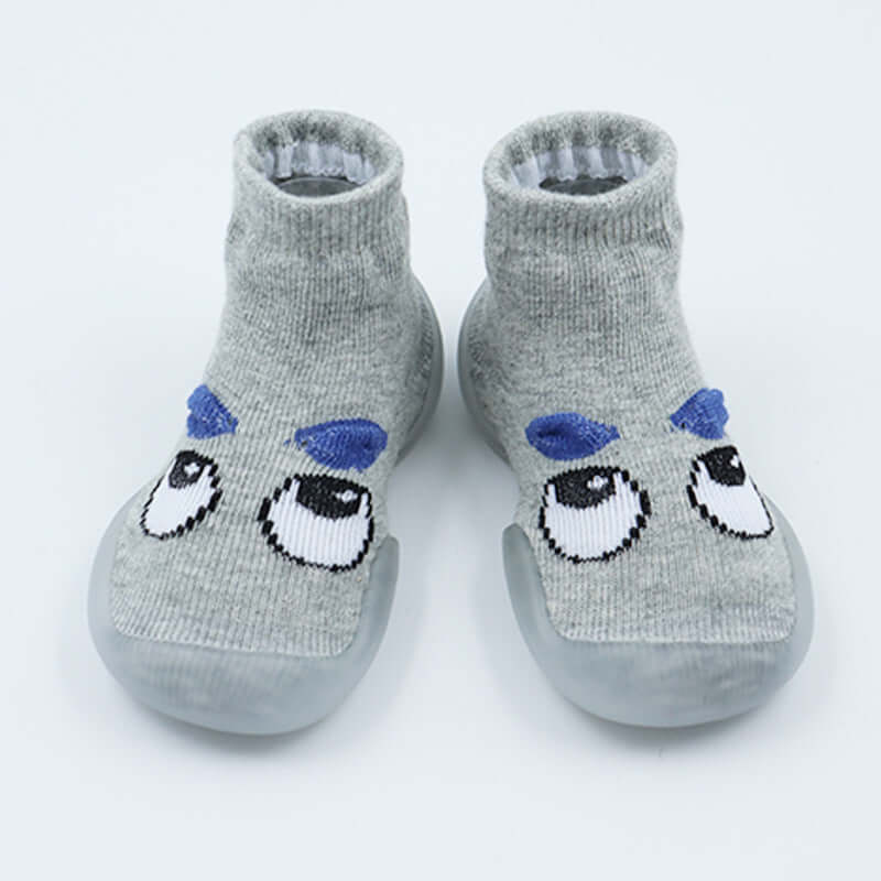 Pair of gray socks with cartoon face design on a white background