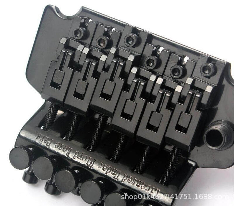 Black guitar bridge with multiple components on a white background