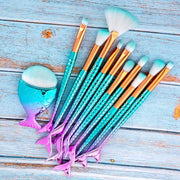 Makeup brushes with mermaid tail design on a wooden surface