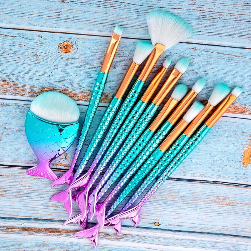 Makeup brushes with mermaid tail design on a wooden surface