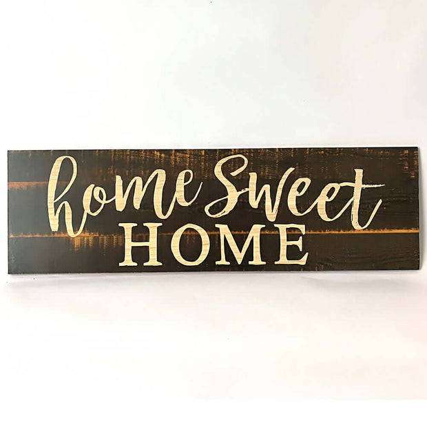 Wooden sign with 'home sweet home' text on a dark background