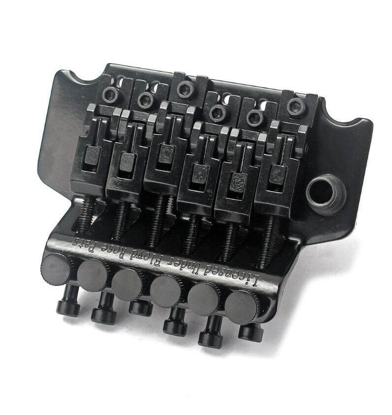 Black guitar bridge with multiple components on a white background