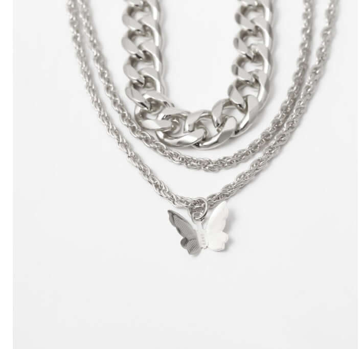 Stack of silver chain necklaces with a butterfly pendant on a white background