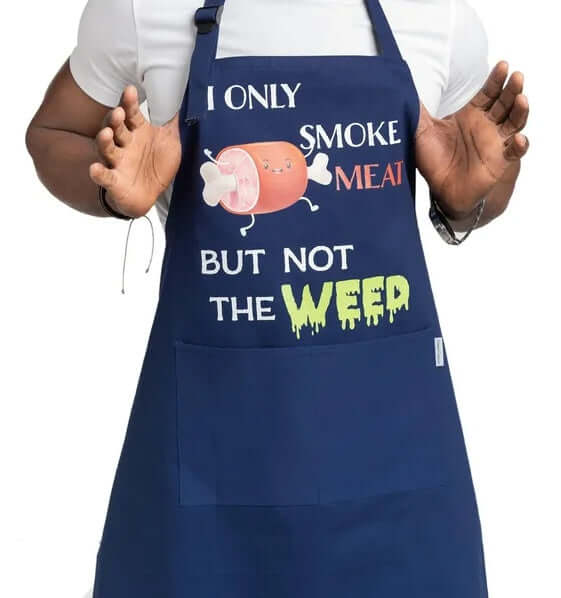 Navy apron with humorous text and graphics worn by a person on a white background