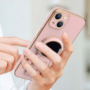 Pink phone case with ring holder held by a hand against a light background