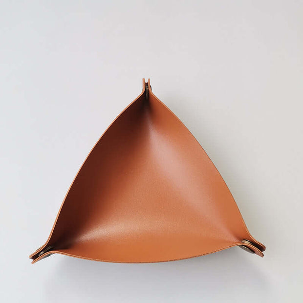 Brown leather triangle-shaped tray on a light gray background