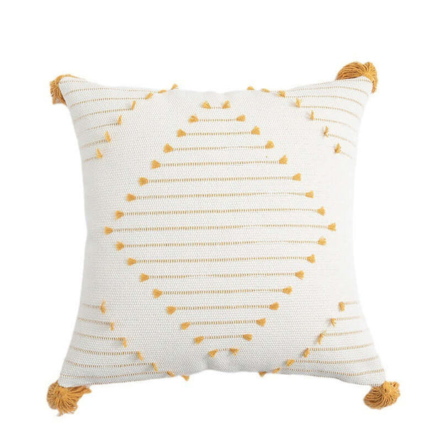 Decorative pillow with yellow patterns and tassels on a white background