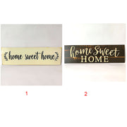 Two 'home sweet home' signs, one gold and one black, on a white background.