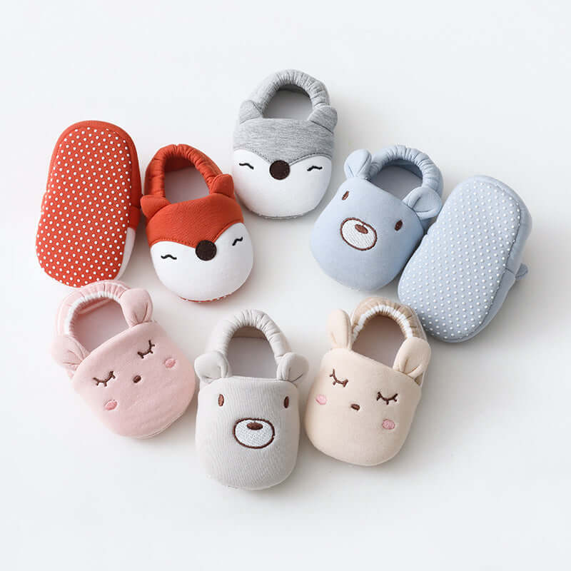 Set of plush animal slippers in various colors on a white background