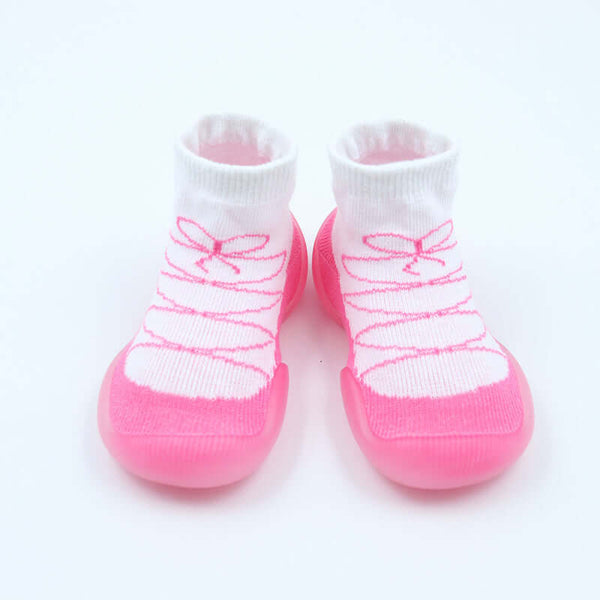 Pair of baby socks with pink soles and white tops on a light pink background