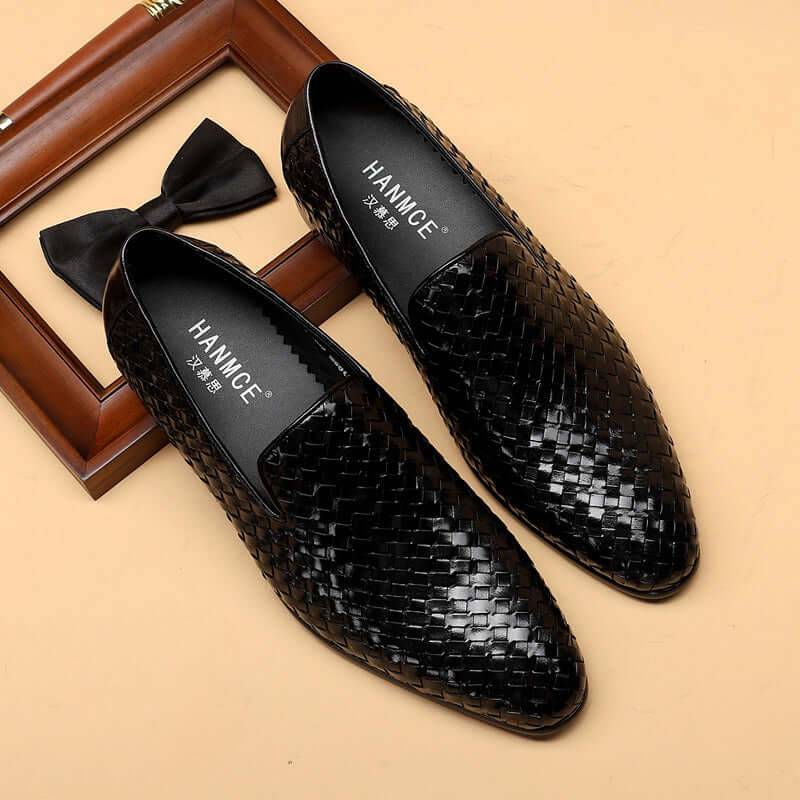 Black woven loafers with 'HANMOE' branding on a beige background