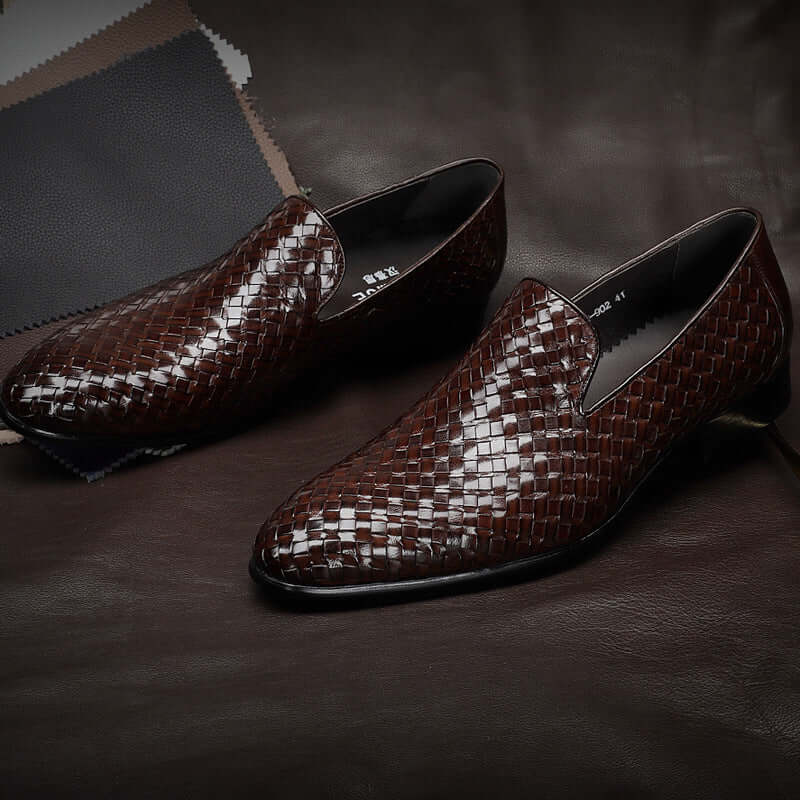 Brown woven loafers on a dark textured surface