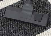 Black vacuum attachment on a textured surface