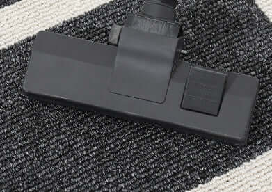 Black vacuum attachment on a textured surface