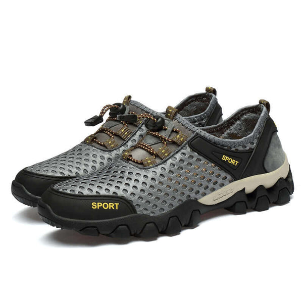 Gray sports shoes with black soles on a white background