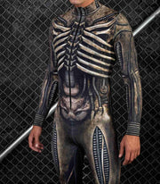 Person wearing a detailed, futuristic suit with metallic and leather textures against a dark chain-link fence background.