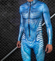 Person wearing a blue textured bodysuit against a chain-link fence background