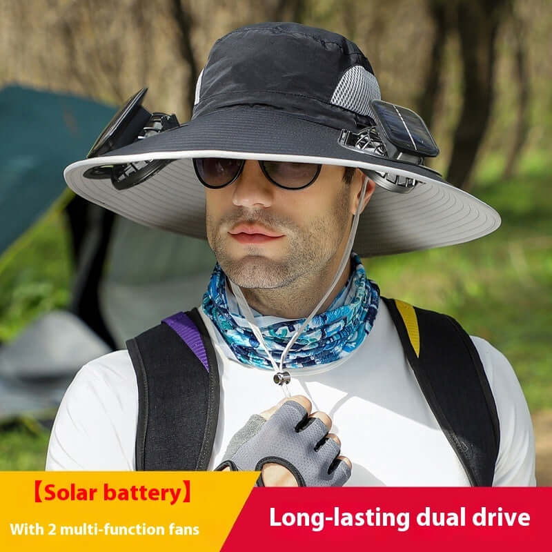 Man wearing a large sun hat with solar battery and fans, outdoors.