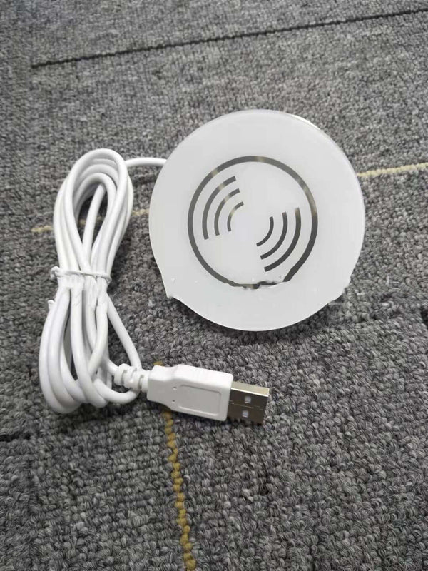Round electronic device with USB cable on a textured surface