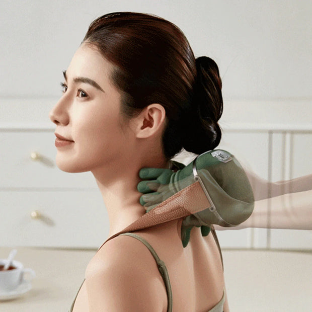 Woman receiving neck and shoulder massage from a green massage device.