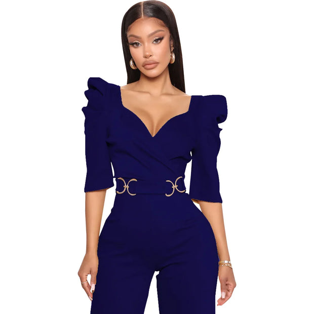 Woman wearing a purple jumpsuit with ruffled sleeves on a white background