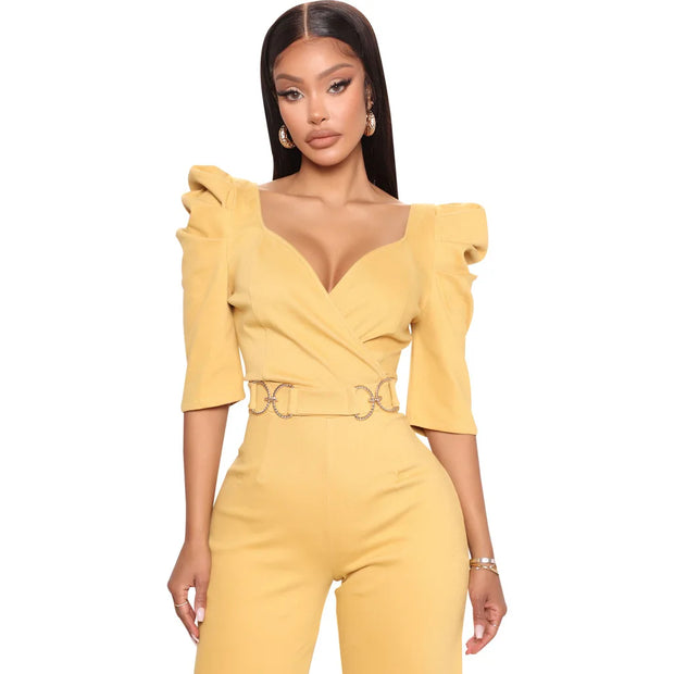 Woman wearing a yellow jumpsuit with ruffled sleeves on a white background