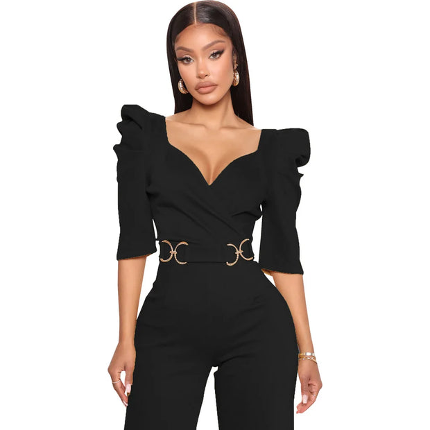 Woman wearing a black jumpsuit with ruffled sleeves on a white background