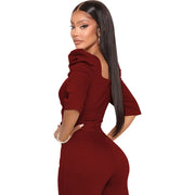 Woman wearing a burgundy jumpsuit on a white background