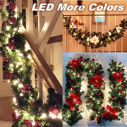 Decorative Christmas garland with lights and red ornaments on a staircase and wall.