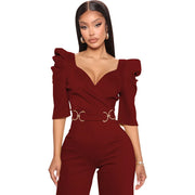Woman wearing a burgundy jumpsuit with ruffled sleeves on a white background