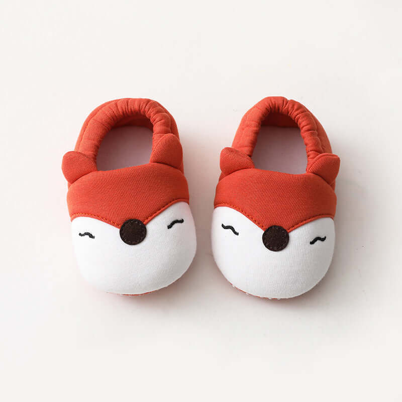 Pair of red and white baby shoes with fox face design on a white background