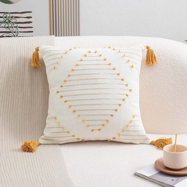 Decorative pillow with yellow tassels on a beige sofa