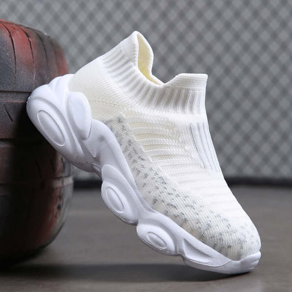 White sock sneaker on a textured surface with a blurred background