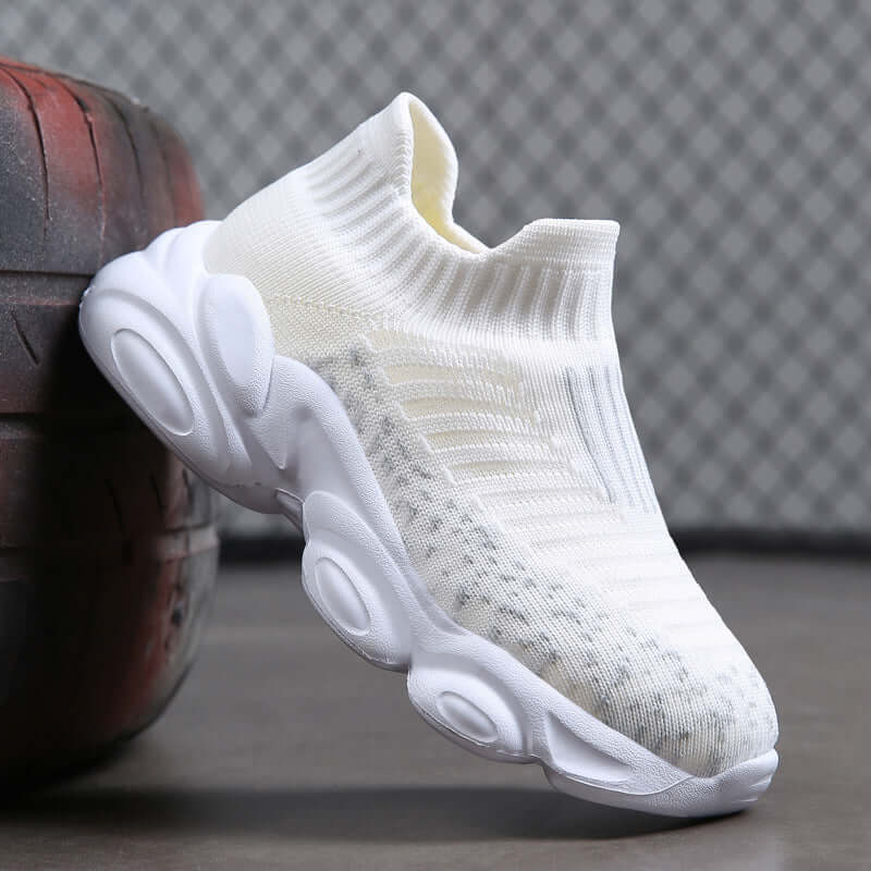 White sock sneaker on a textured surface with a blurred background